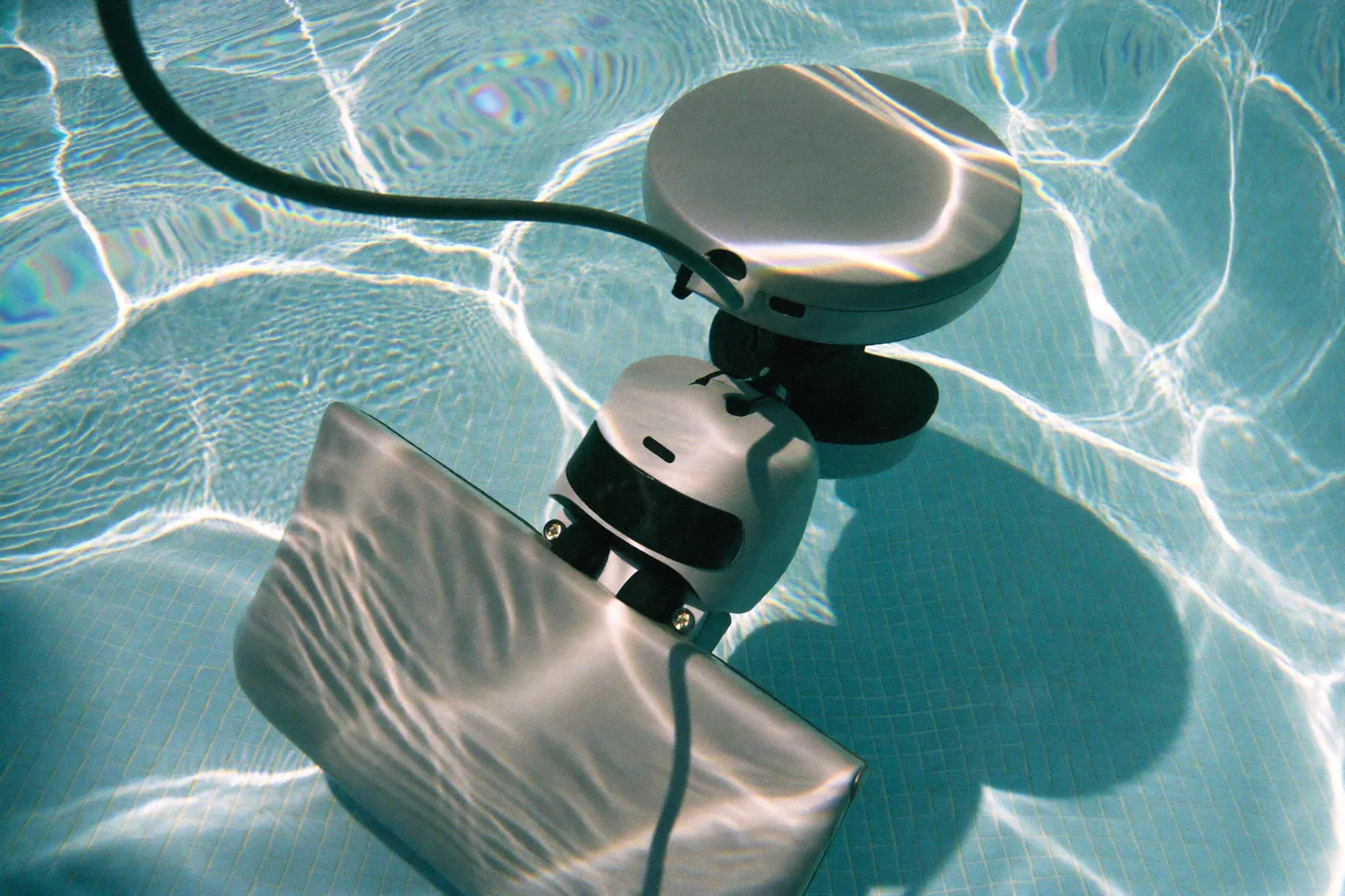 Robotic cleaner working across a sunlit pool floor