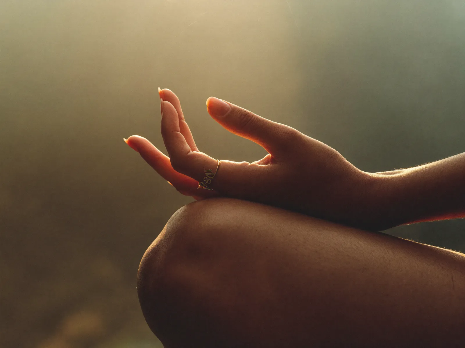 Hands resting in mudra on crossed knees