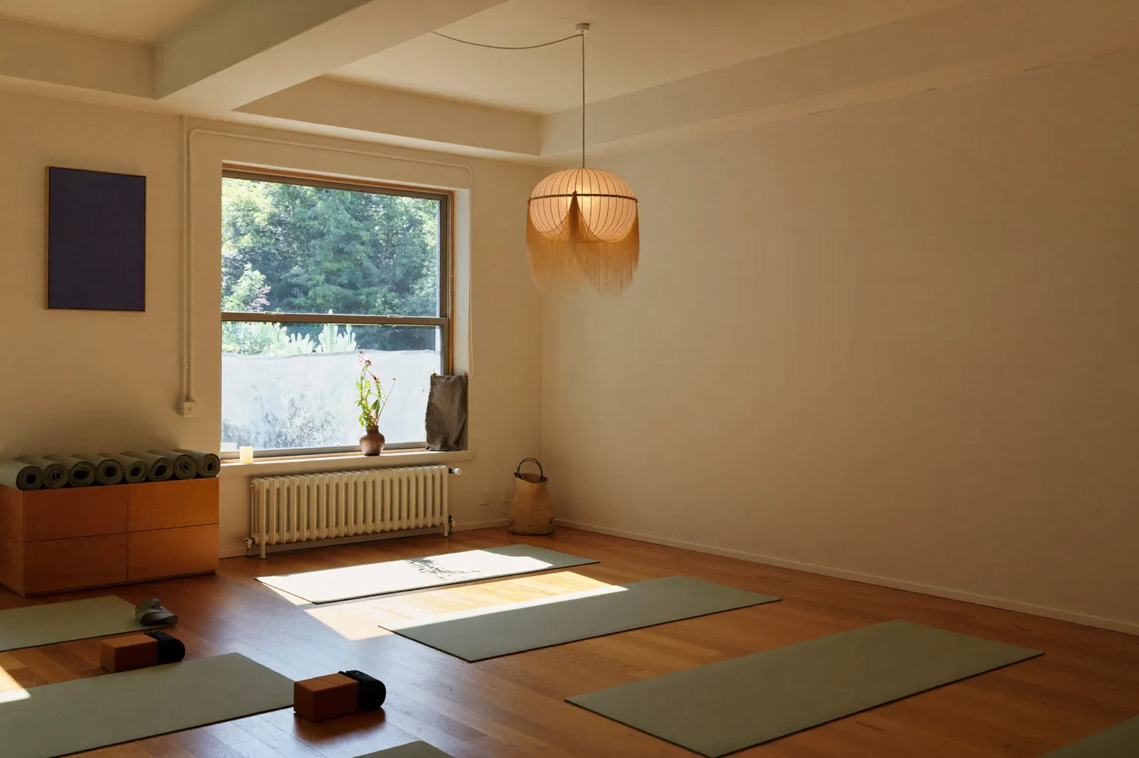 Morning light across mats and cork blocks in a small yoga studio